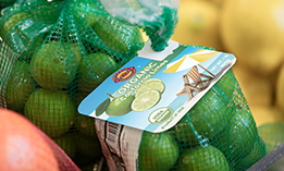 A mesh bag of limes with a Kwik Lok closure and printed label