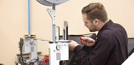 Kwik Lok employee working on machine parts